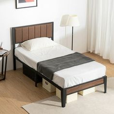 a bed sitting on top of a wooden floor next to a lamp