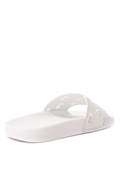 On these white rubber slippers, the diamond-shaped pattern in the form of GG monograms, plays not only a decorative, but also a functional role. An openwork motif, made in the technique of perforations, conducts heat well from the legs. This comfort is also supported by an orthopedic insole that reduces the load on the joints.Composition: Rubber 100%Lining: Rubber 100%Sole: Rubber 100%Made in Italy White Open Toe Slippers With Rubber Sole, Designer White Sandals With Rubber Sole, Classic White Slides With Round Toe, Luxury White Synthetic Sandals, White Studded Open Toe Sandals, White Elegant Synthetic Slippers, Elegant White Flat Slides, White Gucci Sandals With Branded Insole, White Gucci Open Toe Sandals