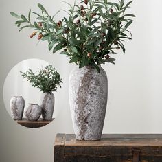 a vase filled with flowers sitting on top of a wooden table next to a mirror