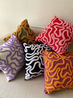 five decorative pillows on a white couch