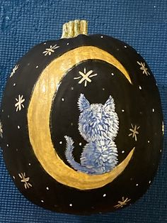 a painted pumpkin with a cat sitting on the moon