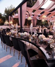 a long table with black chairs and white flowers