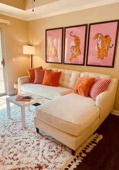 a living room filled with furniture and paintings on the wall