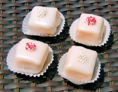 four pieces of cake with white frosting and red sprinkles