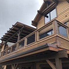 a large wooden house with balcony and railings