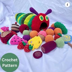 the crochet caterpillar is surrounded by knitted fruits and vegetables