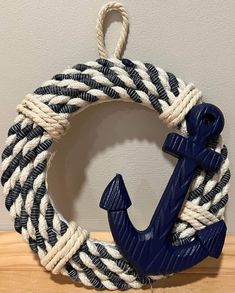 a blue anchor on a white and black rope with a hook hanging from it's center