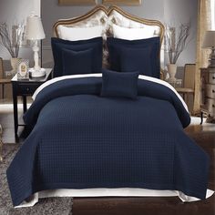 a bed with blue comforters and pillows in a room