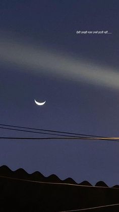 the moon is shining in the sky above some power lines