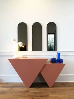 a table with two mirrors on the wall