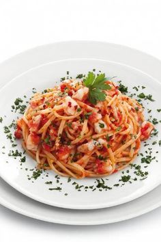 a white plate topped with pasta covered in sauce and garnished with parsley