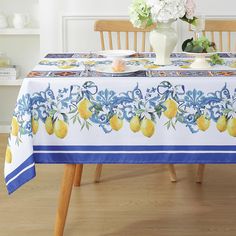 the table cloth has lemons on it and is blue with white trim around the edge