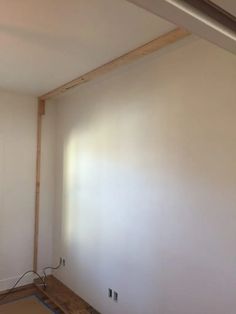 an empty room with white walls and wood framing on the wall is being worked on