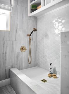 a bathroom with white marble walls and flooring, including a bathtub in the corner