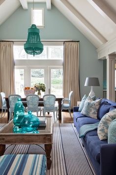 a living room filled with furniture and a blue couch in front of a large window