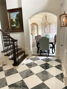 a dining room table and chairs are in the middle of a checkerboard floor