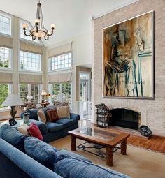 a living room filled with furniture and a painting hanging on the wall over a fire place