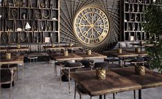 an empty restaurant with wooden tables and chairs in front of a large metal clock on the wall