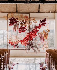 a room filled with lots of chairs and tables covered in red flowers next to a large window