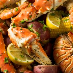 crab legs, potatoes, and corn on the cob are served with lemon wedges