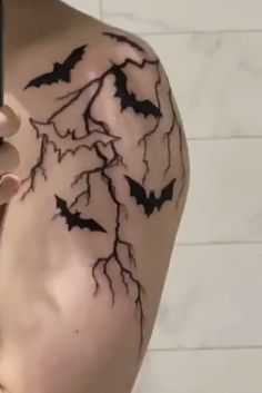 a person holding a cell phone in their left hand with bats on the back of his arm