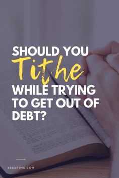 a person holding a book with the words should you tithe while trying to get out of debt?