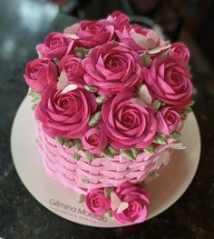 a pink cake decorated with roses on a plate