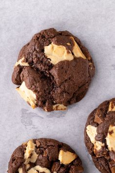 three chocolate cookies with peanut butter on top