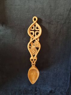 an ornate wooden object hanging on a black background