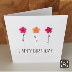 a card with three flowers and the words happy birthday