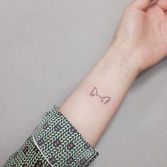 a person's arm with a small tattoo on it that has an arrow in the middle