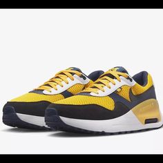 Elevate Your Sneaker Game With These Nike College Air Max Systm Michigan Men's Shoes In Amarillo/Navy. Designed For Athletic And Casual Wear, These Shoes Feature A Lace-Up Closure And Low-Top Shoe Shaft Style For A Secure And Comfortable Fit. The Rubber Outsole Provides Traction While The Arch Support, Cushioning, And Lightweight Design Make These Shoes Ideal For Gym & Training, Walking, School, Cross-Training, Athleisure, Casual, And Running & Jogging.Celebrate Your Love For The University Of M Yellow Synthetic Sneakers With Waffle Outsoles, Navy Running Shoes With Air Max Cushioning For Sports, Navy Running Shoes With Air Cushioning And Round Toe, Navy Running Shoes With Air Cushioning, Navy Sporty Running Shoes With Air Cushioning, Sporty Navy Running Shoes With Air Cushioning, Navy Breathable Sneakers With Round Toe, Breathable Navy Sneakers, Navy Lace-up Sneakers With Air Cushioning