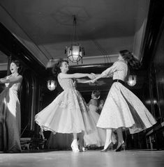 three women in dresses are dancing on stage