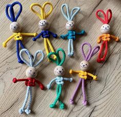 several small knitted bugs are arranged on a table with scissors in the shape of children's hands