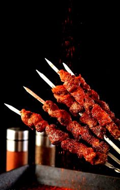 several skewers of meat sitting on top of a grill with toothpicks sticking out of them