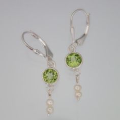 Peridot and dainty Pearl Earrings Secure lever backs Stone size 5mm approx 1.3 inch approx Sterling Silver Drop Pearl Earrings With Lever Back, Handmade Peridot Round Earrings, Handmade Round Peridot Earrings, Peridot Drop Earrings For May Birthstone, Elegant Peridot Earrings With Ear Wire, Elegant Peridot Dangle Earrings, Peridot Dangle Earrings With Ear Wire, Nickel-free Round Peridot Earrings, Dainty Pearl Earrings