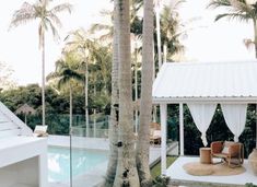 an outdoor pool area with chairs, tables and umbrellas