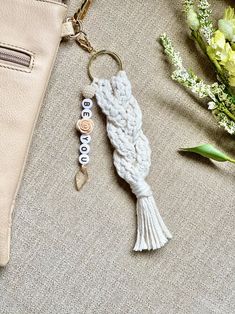 a white keychain sitting on top of a table next to flowers