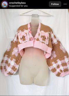 a white mannequin wearing a pink and brown knitted teddy bear cardigan