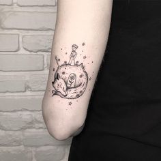 a woman's arm with a small tattoo on it