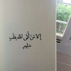 arabic writing is written on the side of a wall in a room with an open window