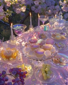 a table topped with plates filled with cupcakes and muffins