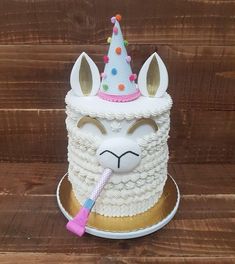 a white cake with a unicorn face and a pink toothbrush in it's mouth