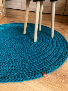 a blue rug with wooden legs on the floor