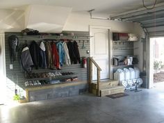 the inside of a garage with lots of clothes and shoes hanging on the wall next to it