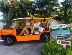 a woman is sitting in an orange golf cart