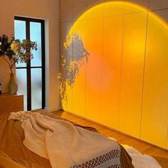 the sun is shining brightly on the wall behind a bed in a room with wooden floors