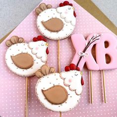 three decorated cupcakes sitting on top of a pink table