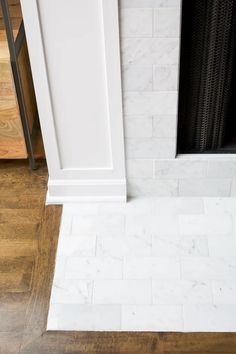 a fireplace with white marble and wood flooring