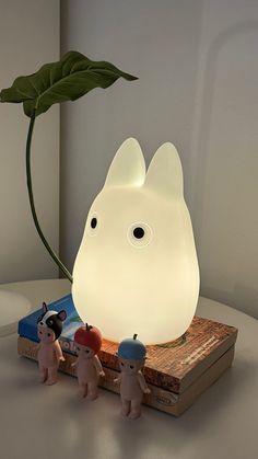 a white lamp sitting on top of a table next to two small figurines